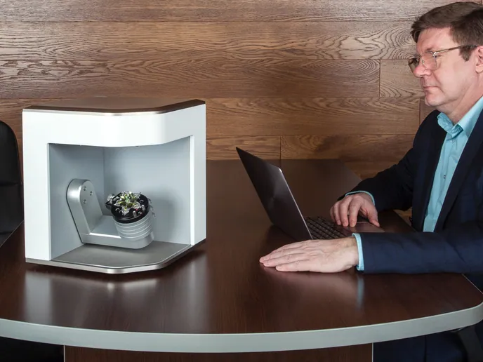 A specialist demonstrating the desktop Artec Micro across a table